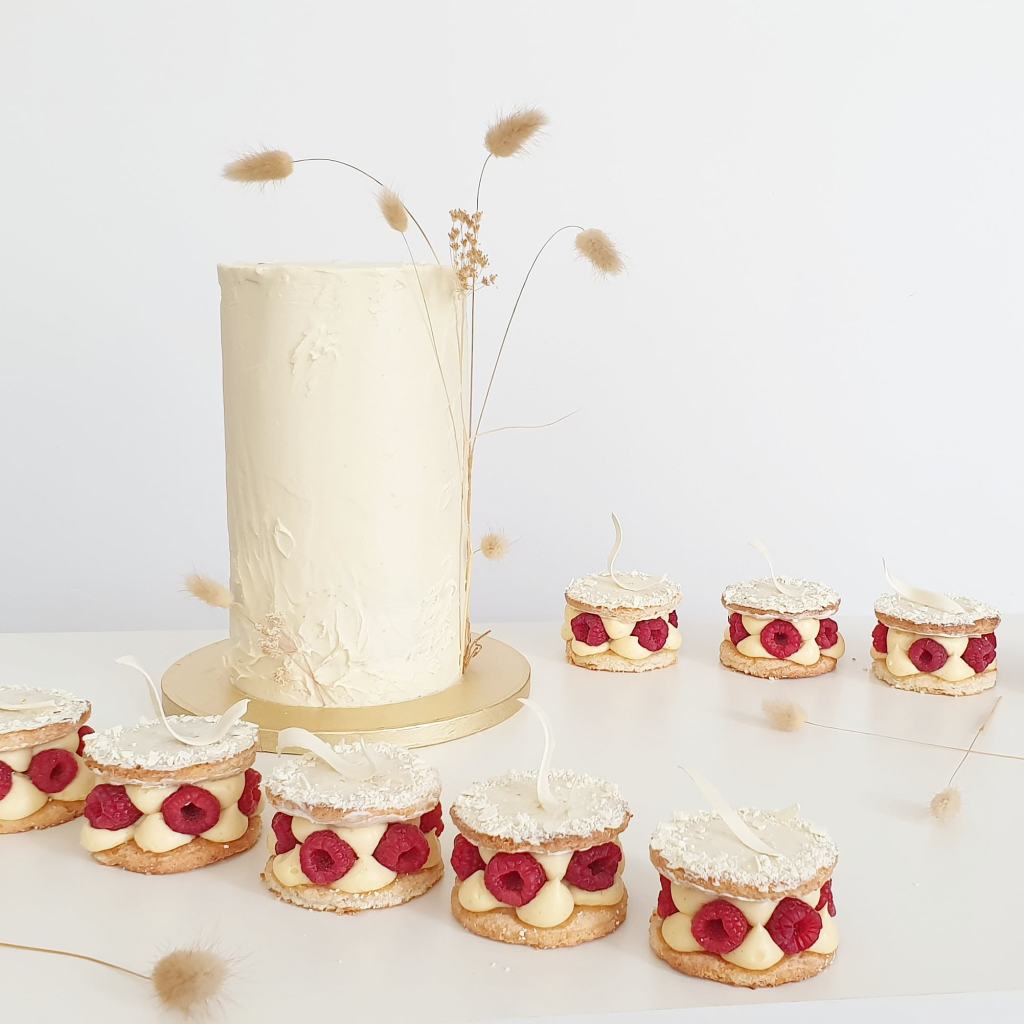 elegante bruidstaart met bijpassende frambozen gebakjes