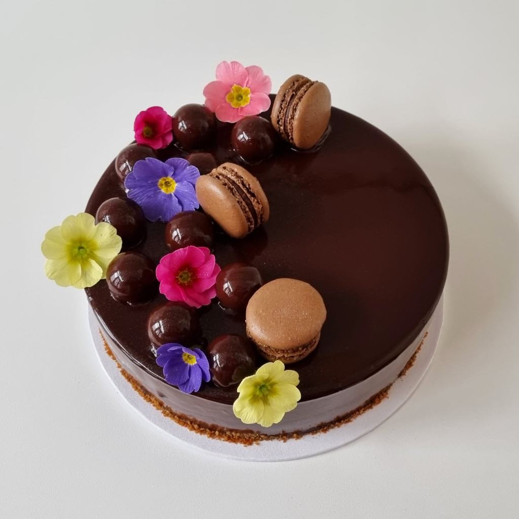 chocolade verjaardagstaart met eetbare bloemen en macarons